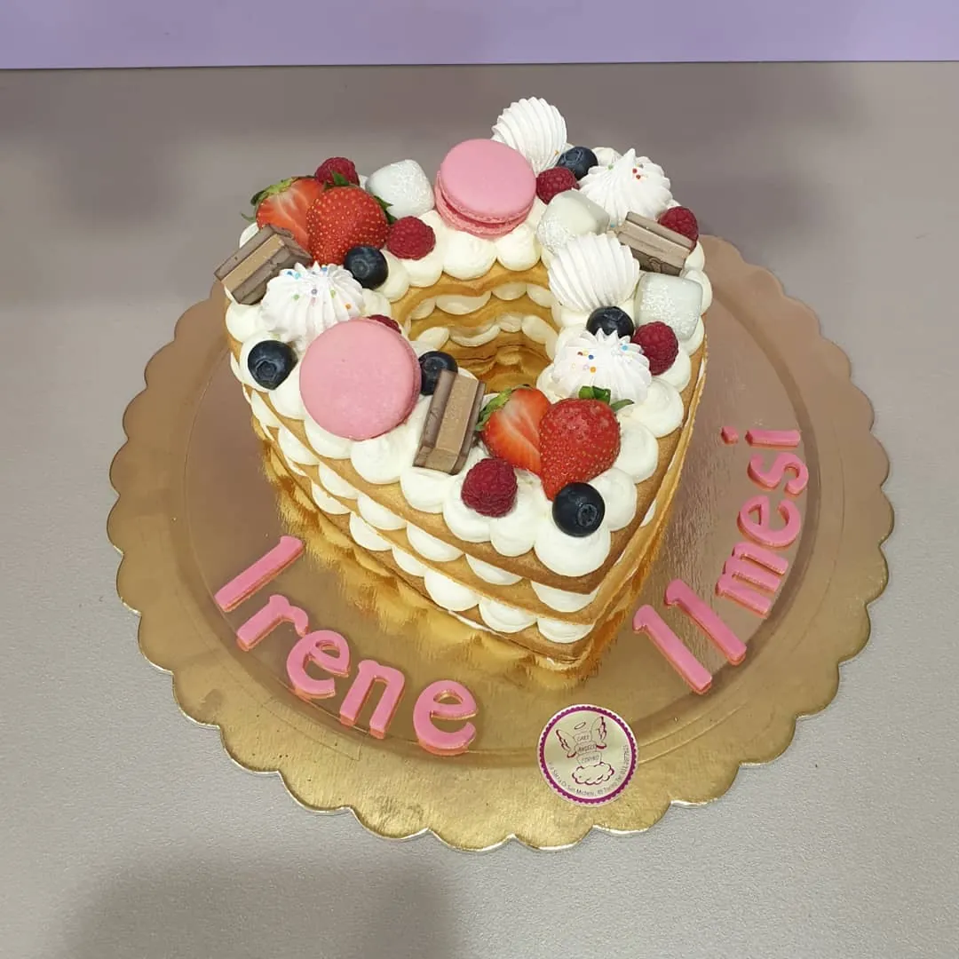 Cream tart a forma di cuore con macarons, fragole e meringhe